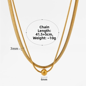 Detailed view of double layered gold snake chain necklace with flat link and bead charm