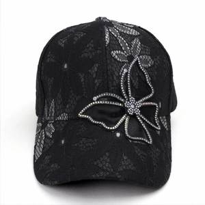 Detail of black lace baseball cap featuring a large sparkling rhinestone butterfly design