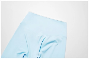 Detail van de lichtblauwe yoga broek met hoge taille, witte bies en versterkte naden
