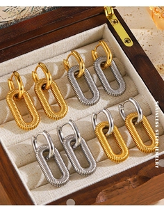 Detailed close-up of oval stainless steel textured hoop earrings in gold and silver