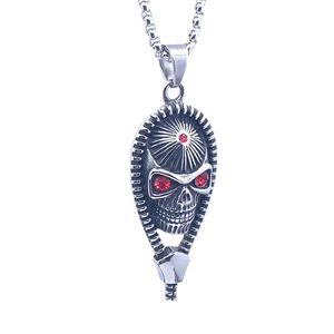 Vintage Indian style skull pendant in silver steel with red gemstones on a white background