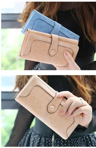 Detalle de carteras largas de cuero vintage en azul y rosa con hebilla y costuras