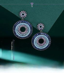 Detailed macro view of large round drop earrings with blue and purple crystal gradient inlay