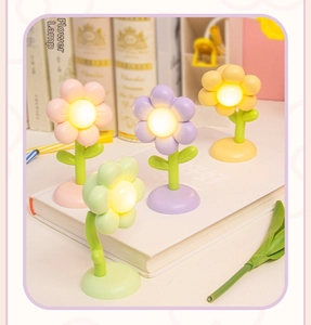 Macro detail of cute flower night lamps in four pastel colors on a desktop book
