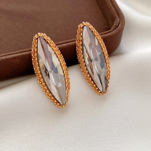 Detailed macro view of marquise-cut crystal earrings with elegant gold beaded edges