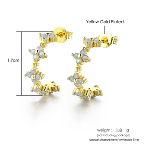 Gold C-shaped stud earrings with micro-set blue zircon flower accents on white background
