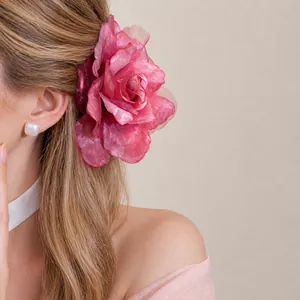 Eleganter übergroßer rosa Netz-Blumen-Haarclip an Modell für modischen Urlaubslook