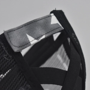 Detail of adjustable camouflage strap and crisscross elastic bands on black mesh cap