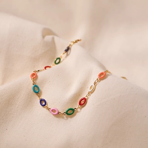 Detailed macro view of gold-plated chain bracelet with colorful enamel oval links