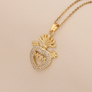 Detailed view of a gold heart pendant with MOM lettering, small crown and crystal accents