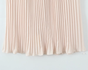 Detail of light pink pleated dress hem showing vertical folds and fine stitching