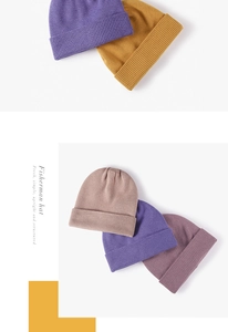 Detail of ribbed knit winter beanies in purple, ginger, and beige tones for women