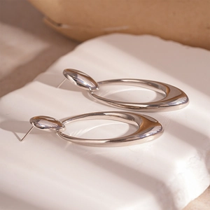 Detail view of silver hollow oval metal earrings with minimalist geometric design