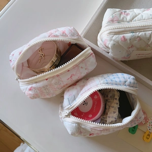 Gros plan détaillé des trousses matelassées fleuries avec coton doux et fermeture
