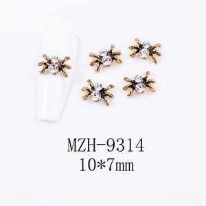 Detail of spider nail art charms with crystal rhinestones on a white nail plate