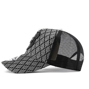 Close-up of baseball cap with black and white checkered texture and breathable mesh back