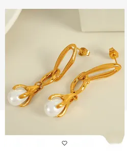 Detail of 18K gold chain earrings with elegant white teardrop pearl pendants