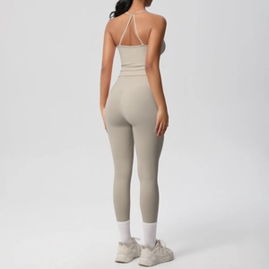 Detail of high-waist yoga leggings and cross-back sports bra in light stone beige fabric
