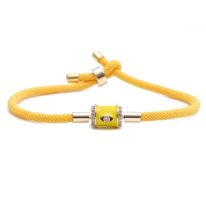 Yellow woven cord bracelet with gold evil eye charm and sparkling zircon accents
