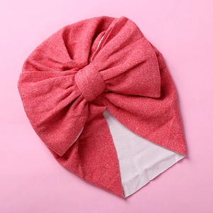 Detailed view of the double-layered bow and elastic knit fabric on a baby turban hat
