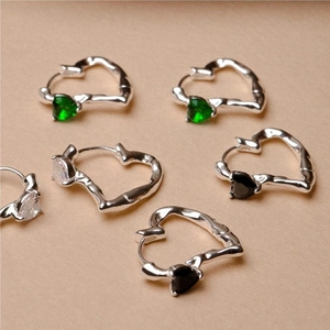 Detail of 925 silver heart hoop earrings with irregular lava texture and colored stones