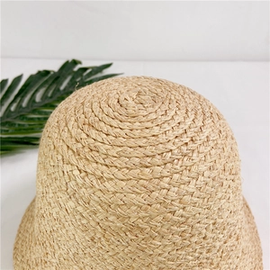Macro view showing the spiral woven texture of the raffia bucket hat crown