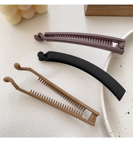 Detailed view of matte banana hair clips in purple, black and khaki with inner comb teeth