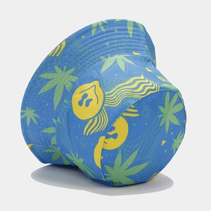 Close-up of blue reversible bucket hat featuring yellow ghost patterns and green leaf prints