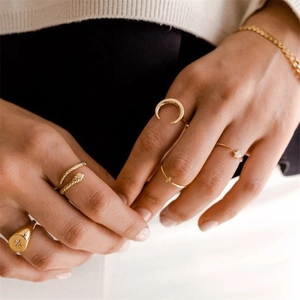 Detail of stacked gold S925 sterling silver rings with snake and moon star motifs