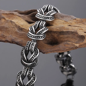Détail macro d'un bracelet en acier titane punk avec texture à pois sur bois naturel