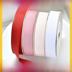 Close-up of high-density grosgrain ribbons in four colors with ribbed texture on a plate