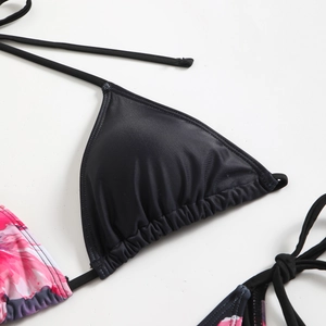Detailed close-up of a black bikini top featuring floral prints and adjustable ties