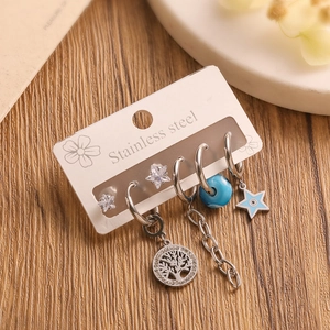 Detailed macro view of a stainless steel earring set with Tree of Life and star motifs