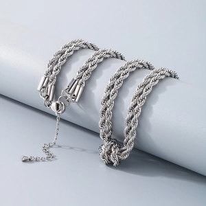 Silver double-layer twisted chain necklace in titanium steel displayed on a pedestal