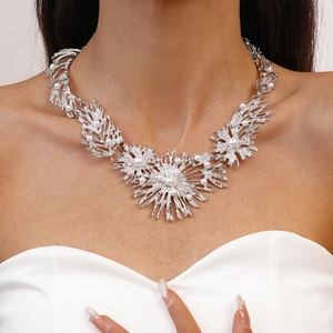 Detail of silver leaf-shaped statement necklace with pearls on a female model