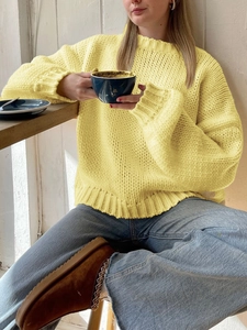 Detail of yellow chunky knit sweater showing comfortable crew neck and loose long sleeve style
