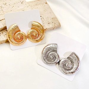 Detailed view of conch shell alloy stud earrings in bright gold and silver finishes