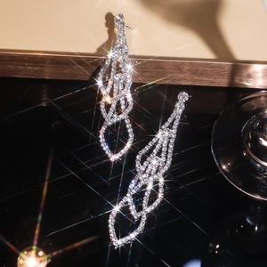 Macro shot of silver rhinestone tassel earrings with sparkling starburst light effects