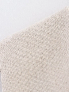 Detailed macro view of the cream linen fabric texture on the summer v-neck vest set