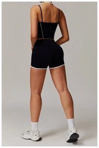 Detailansicht von Racerback-Yogatop und High-Waist-Sportshorts mit weißer Paspelierung