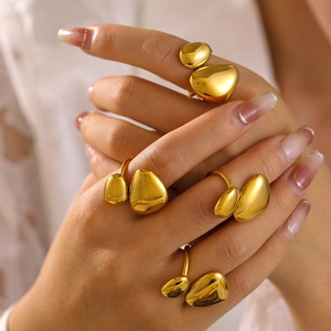 Set of four irregular polished 18K gold plated stainless steel open rings worn on a hand