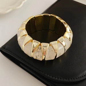Close-up of vintage stretch bracelet with gold metal and marble resin diamond panels