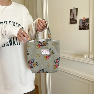 Detail of grey-green corduroy tote bag with Keep Smiling print and magnetic metal clasp