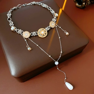 Detail of vintage necklace with sun totem, teardrop pearls and crystals on leather box