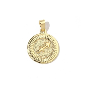 Macro shot of 18k gold plated round Sagittarius charm with embossed zodiac symbol detail