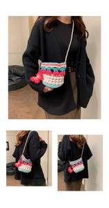 Detail of crochet bucket bag with red cherry charm and elegant pearl shoulder strap