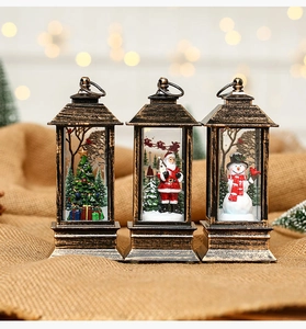 Three bronze Christmas lanterns featuring Santa, a snowman, and a tree on plush fabric