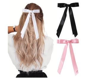Détail de grandes barrettes nœud en satin avec longs rubans en blanc, noir et rose