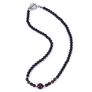 Macro detail of obsidian bead necklace with tiger eye accents and silver T-bar toggle clasp