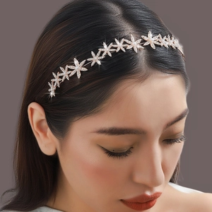 Serre-tête élégant en or rose avec flocons de neige, strass et perles sur modèle